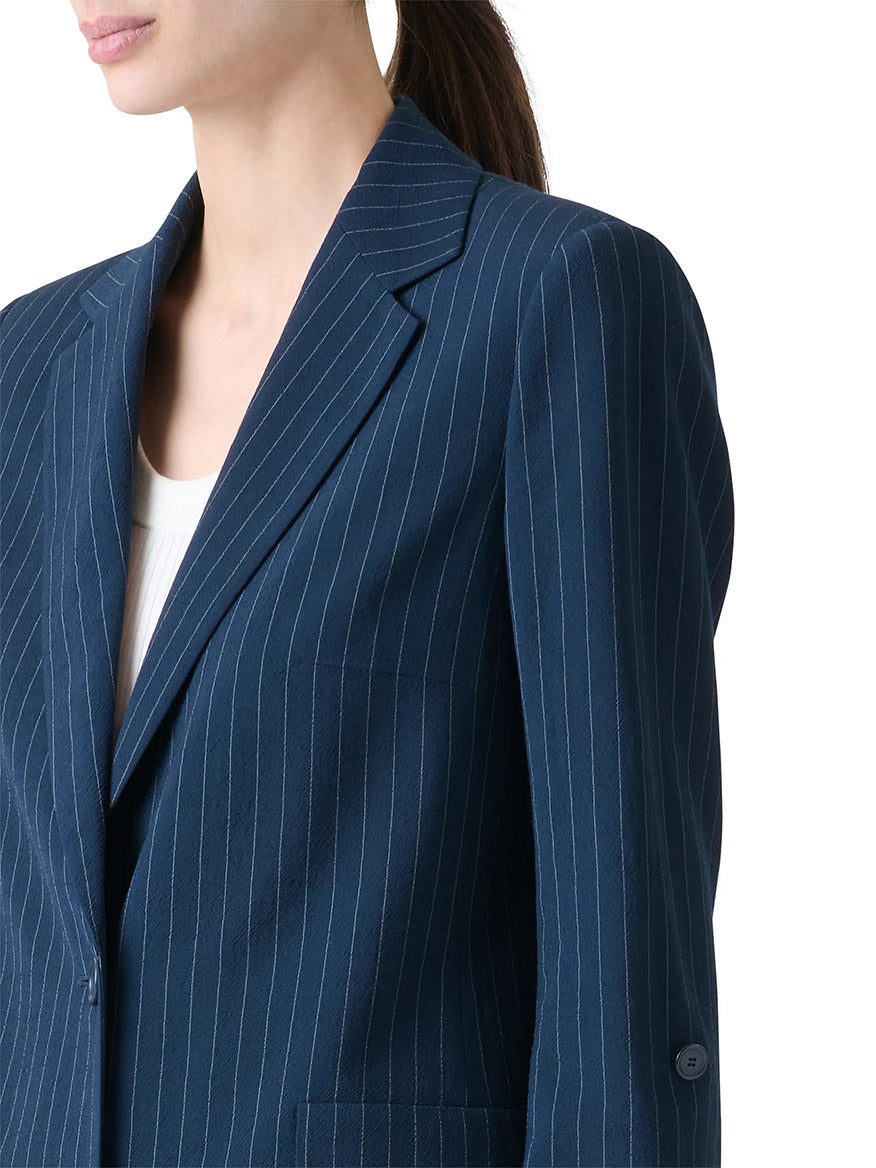 A woman models the Akris Punto Pinstripe Virgin Wool Jacket in Navy/Cream over a white top, shown from shoulders to waist against a plain white background.