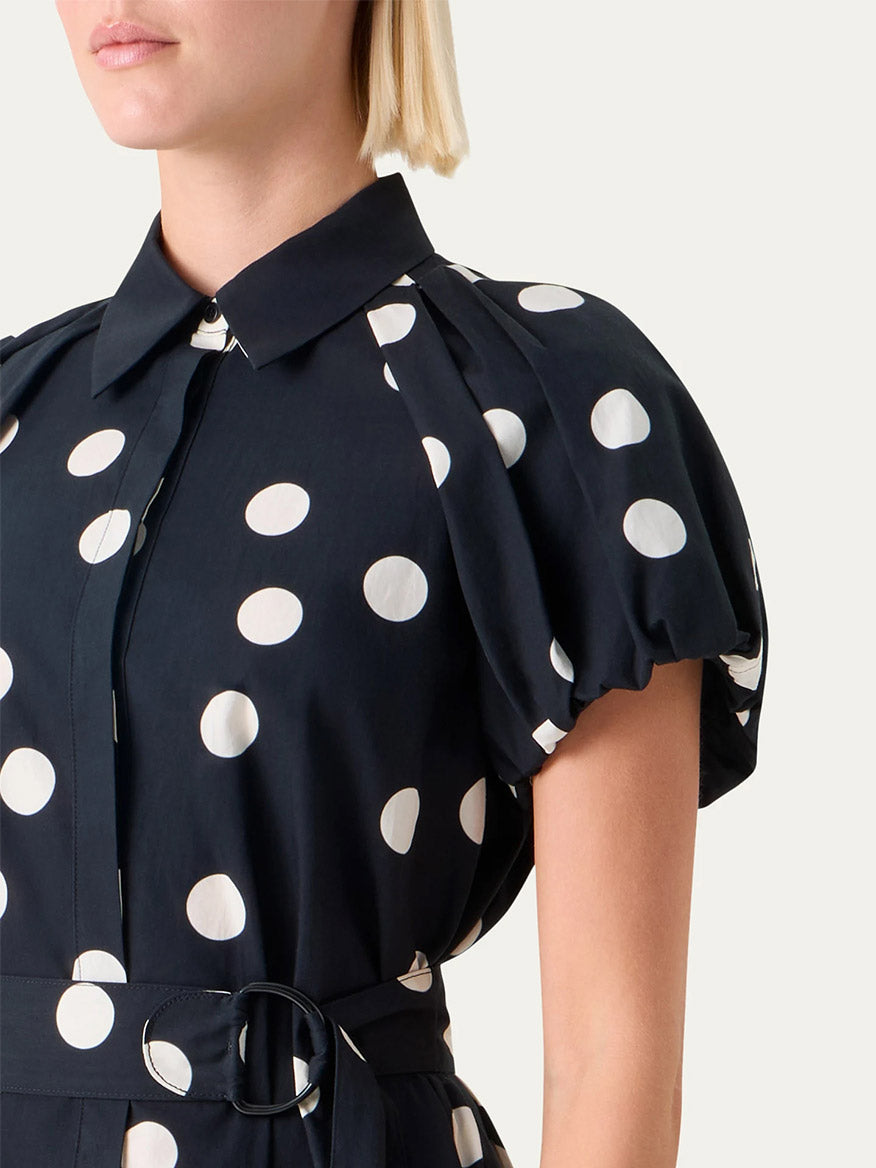 Someone wearing the Akris Punto Polka Dot Balloon Sleeve Shirtdress in Black/Cream, featuring short balloon sleeves and a belted waist.