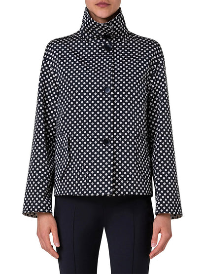 A person wearing the Akris Punto Reversible Polka Dot Jacket in Black/Navy with black pants, standing facing forward.