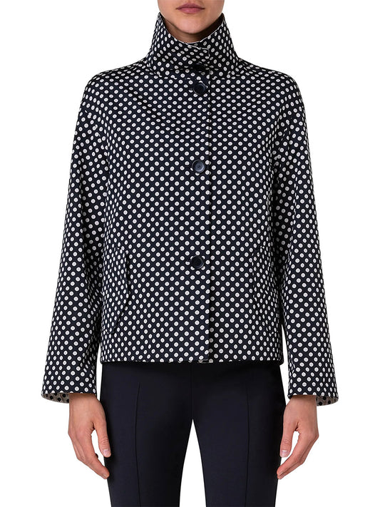 Someone is wearing the Akris Punto Reversible Polka Dot Jacket in Black/Cream, featuring a black cropped design with white polka dots, a high collar, large buttons, and a boxy silhouette, paired with black pants.