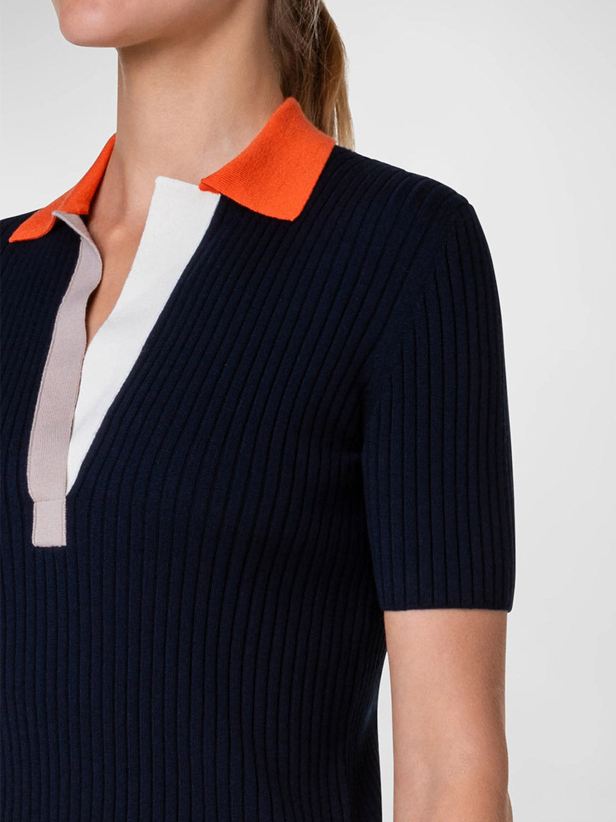 A woman sporting an Akris Punto Ribbed Wool Polo Top in Navy Multi with contrast detailing.