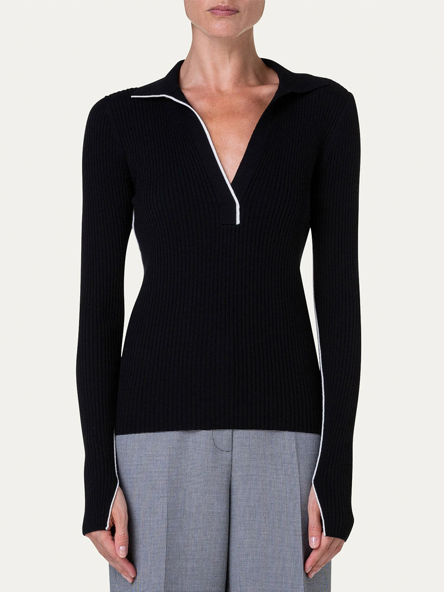 A woman wearing the Akris Punto Ribbed Wool Polo Top in Black/Cream with fitted silhouette black sweater.
