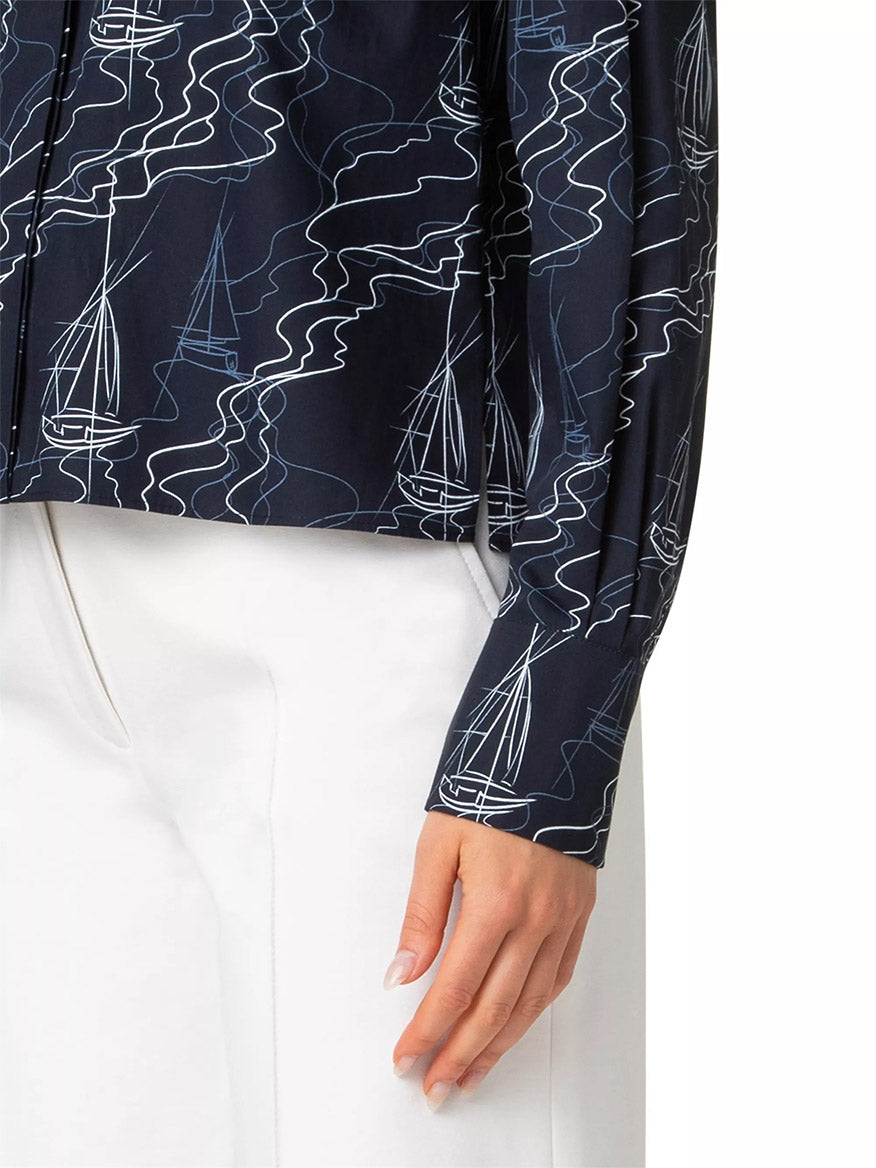 A person wearing the Akris Punto Sailboat Print Poplin Top in Navy/Cream and white pants showcases a relaxed, drop-shoulder silhouette with a visible hand.