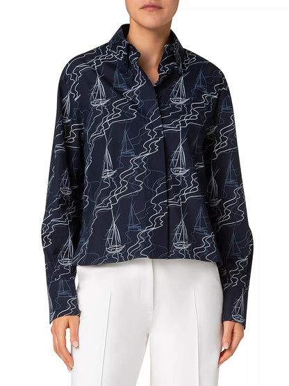 A person is wearing the Akris Punto Sailboat Print Poplin Top in Navy/Cream, featuring a sailboat pattern with a johnny collar, drop-shoulder design, and loose fit, paired with white pants. The face is not visible.