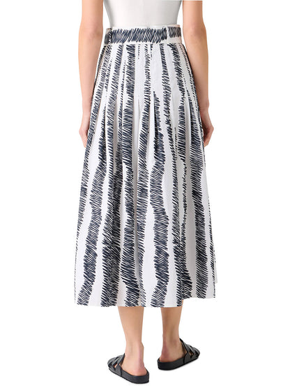 A person shown from the back wears a white sleeveless top, the Akris Punto Scribble Wave Print Midi Skirt in Cream/Black, and black sandals.