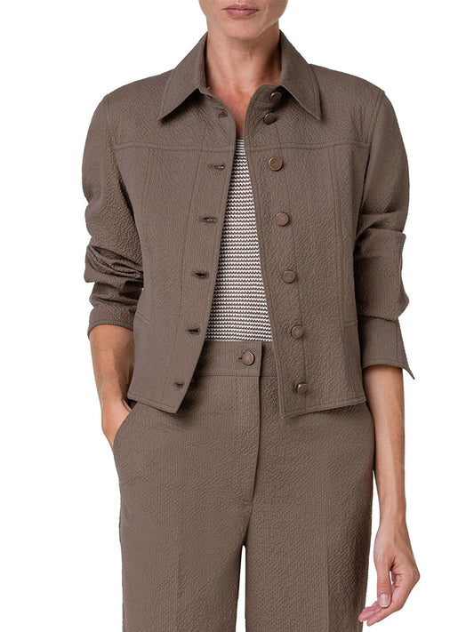 Woman wearing a brown Akris Punto Cropped Seersucker Jacket in Nutmeg and pants set with a patterned white blouse.