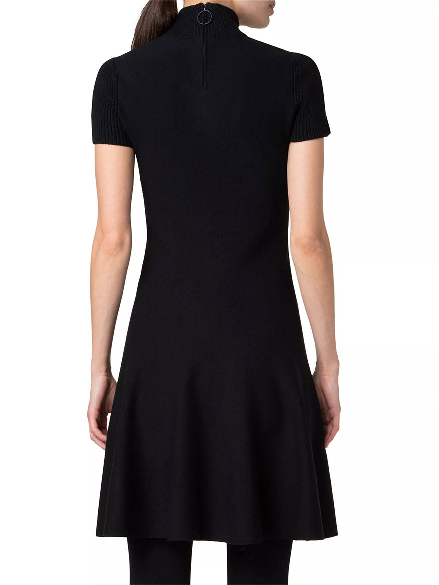 A person wearing the Akris Punto Short Fit-and-Flare Mockneck Wool Dress in black, viewed from the back.