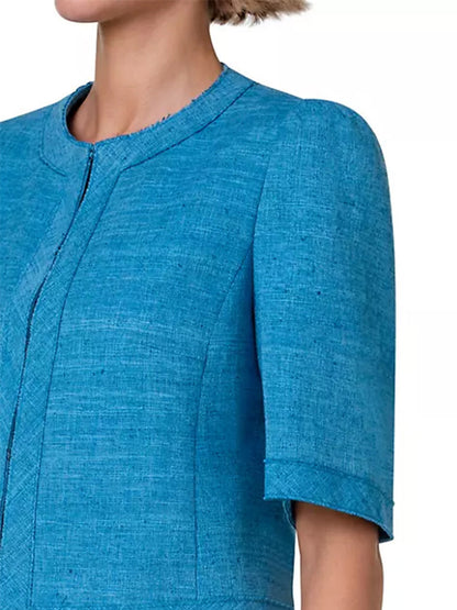 A woman is wearing a tailored blue Akris Punto Short Sleeve Silk Blend Jacket in Medium Blue.