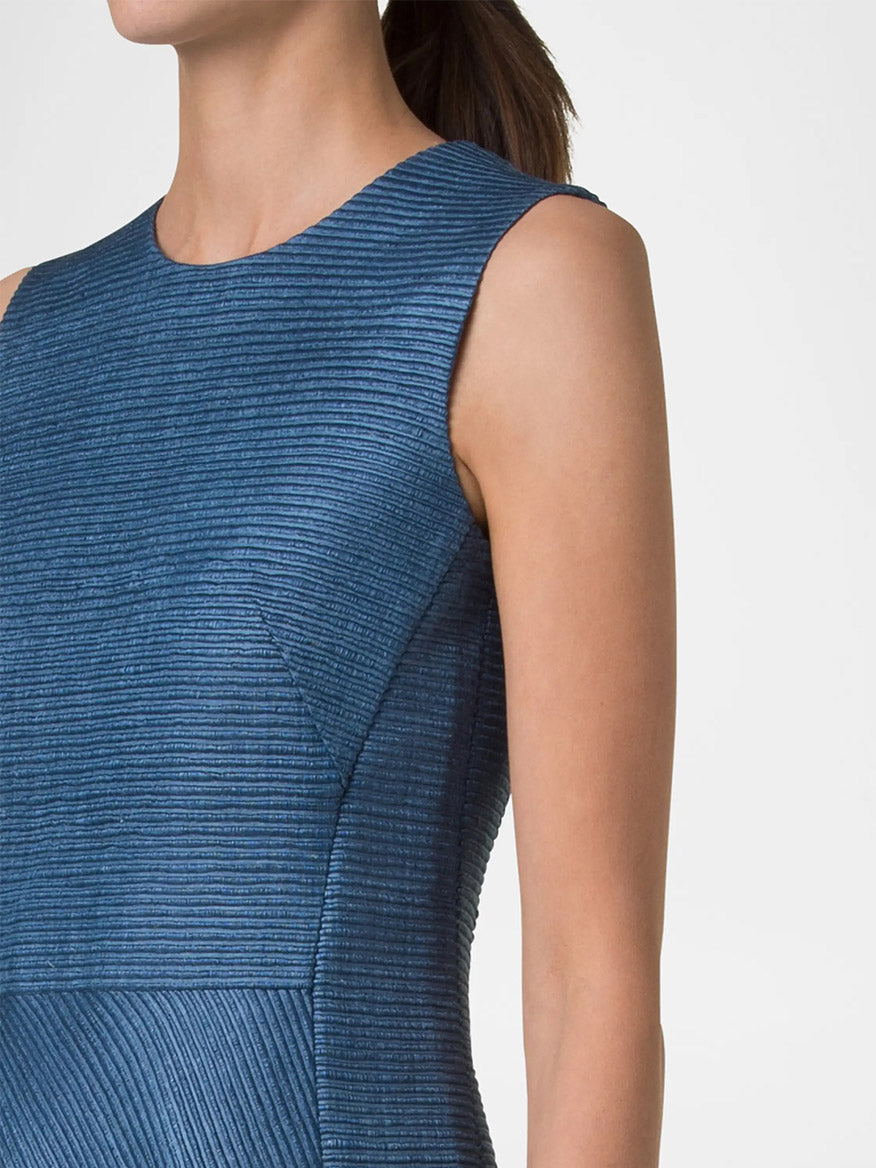 A person wears an Akris Punto Sleeveless Silk Ottoman Shift Dress in Medium Blue, featuring a luxurious textured hue and a round neckline, viewed from shoulders to waist against a neutral background.