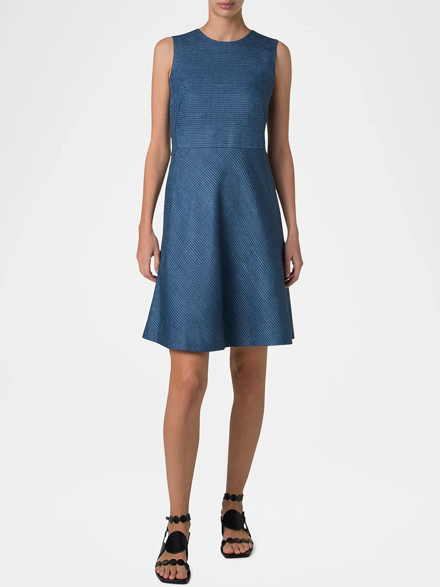 A person wearing the Akris Punto Sleeveless Silk Ottoman Shift Dress in medium blue stands against a plain background, showcasing black sandals.