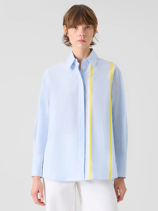 A person wears the Akris Punto Striped Cotton Chambré Shirt Blouse in Sky/Lemon/Cream paired with white pants, standing against a plain background.