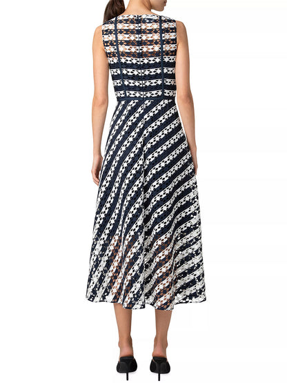 Back view of a woman in an Akris Punto Striped Dot Guipure Lace Maxi Dress in Navy/Cream, paired with black heels.