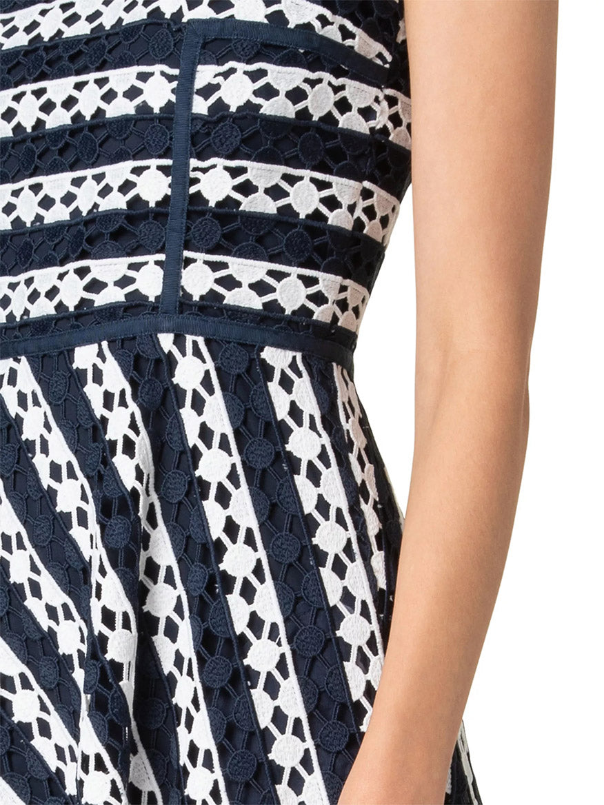 Close-up of the Akris Punto Striped Dot Guipure Lace Maxi Dress in Navy/Cream, highlighting its geometric lace patterns with diagonal stripes. Person's arm and part of the torso are visible on the right.