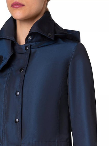 A close-up view of a person wearing an Akris Punto Techno Water Resistant Satin Short Jacket in Ink, featuring a high snap-button collar.