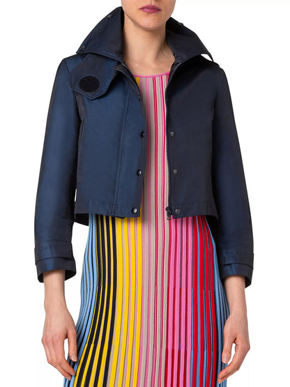 A person wearing an Akris Punto Techno Water Resistant Satin Short Jacket in Ink over a colorful vertical striped dress. The person's face is not visible.