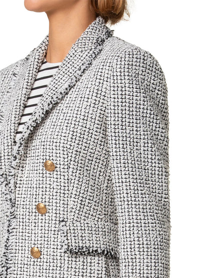 A person wearing an Akris Punto Tweed Illusion Double Breasted Jacket in cream/black cotton-blend tweed with gold buttons, layered over a black and white striped shirt.