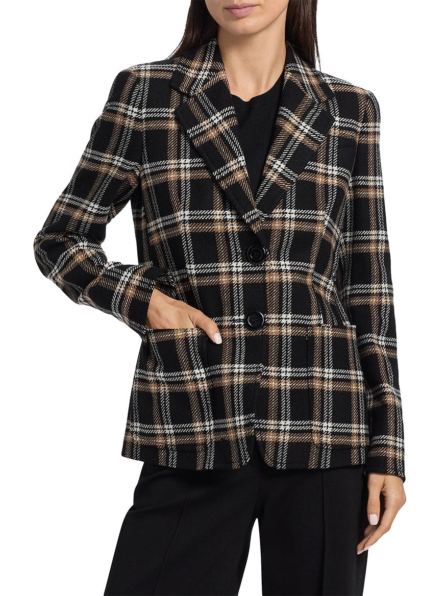 A woman wears the Akris Punto Tweed Plaid Structured Blazer in Black/Camel/Cream with black trousers and a black top, standing with one hand in her pocket.