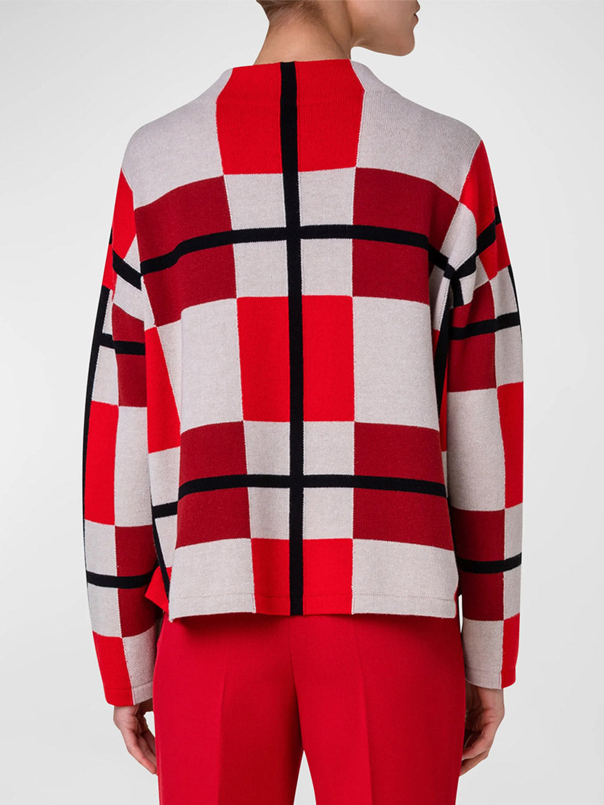 A woman wearing an Akris Punto XL Cube Check Funnel Neck Sweater in Red Multi.