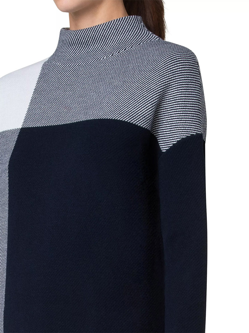 A person wearing the Akris Punto XL Gingham Merino Wool Mock Neck in Cream/Navy. The person's face is not visible in the image.