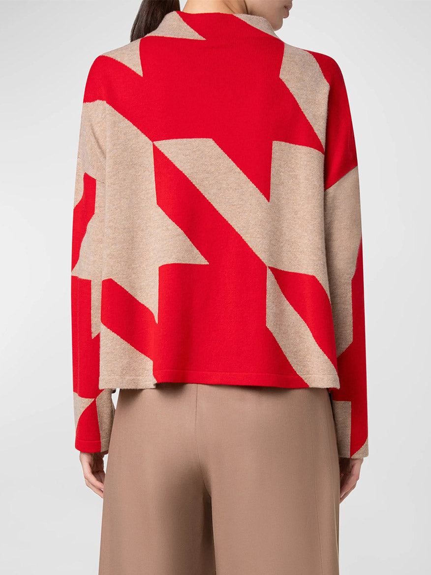 A person is wearing the Akris Punto XL Houndstooth Wool/Cashmere Mockneck in Lipstick/Caramel and beige pants, viewed from the back.