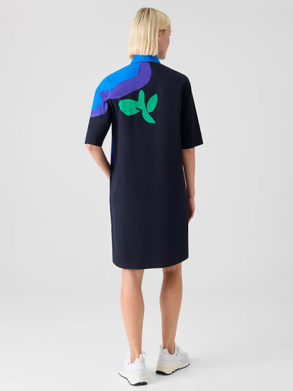 A person with short blonde hair wears the Akris Punto XL Pop Dot Flower Cotton Dress in Black Multi, paired with white sneakers.