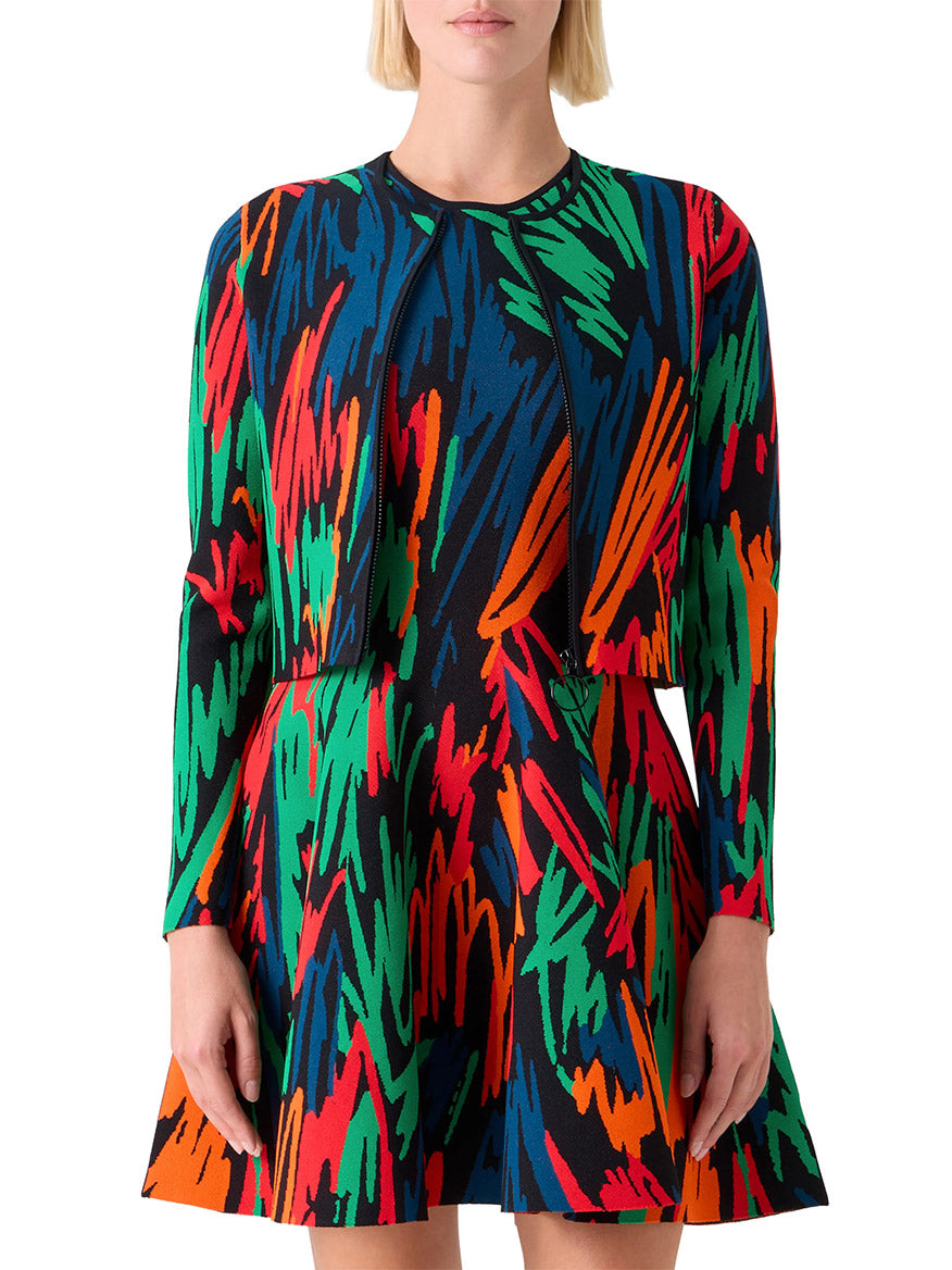 A woman wearing the Akris Punto Scribble Jacquard Cardigan in Black Multi, featuring a colorful crayon-scribble print in red, green, blue, orange, and black.