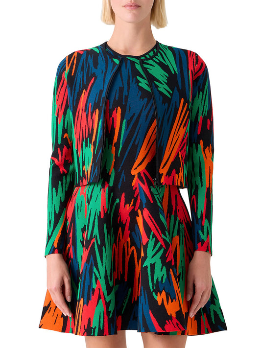 A woman wearing the Akris Punto Scribble Jacquard Cardigan in Black Multi, featuring a colorful crayon-scribble print in red, green, blue, orange, and black.