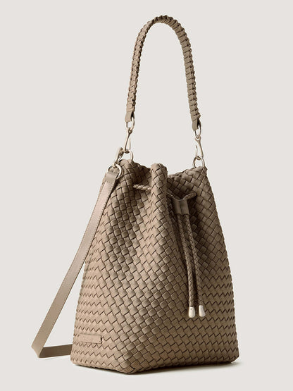 Naghedi Mercer Large Bucket in Cashmere, a light beige handwoven bucket bag featuring a braided shoulder strap and a drawstring closure.