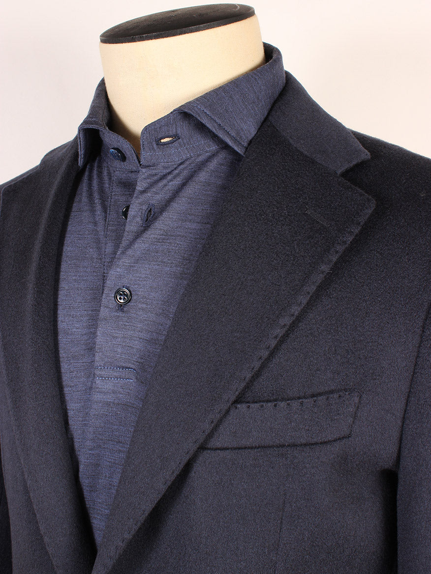 A close-up of a mannequin dressed in the Maurizio Baldassari Soft 2-Button Blazer in Dark Blue over a blue button-up shirt. Made in Italy, the blazer features a notch lapel and a chest pocket, while the shirt includes a buttoned placket.