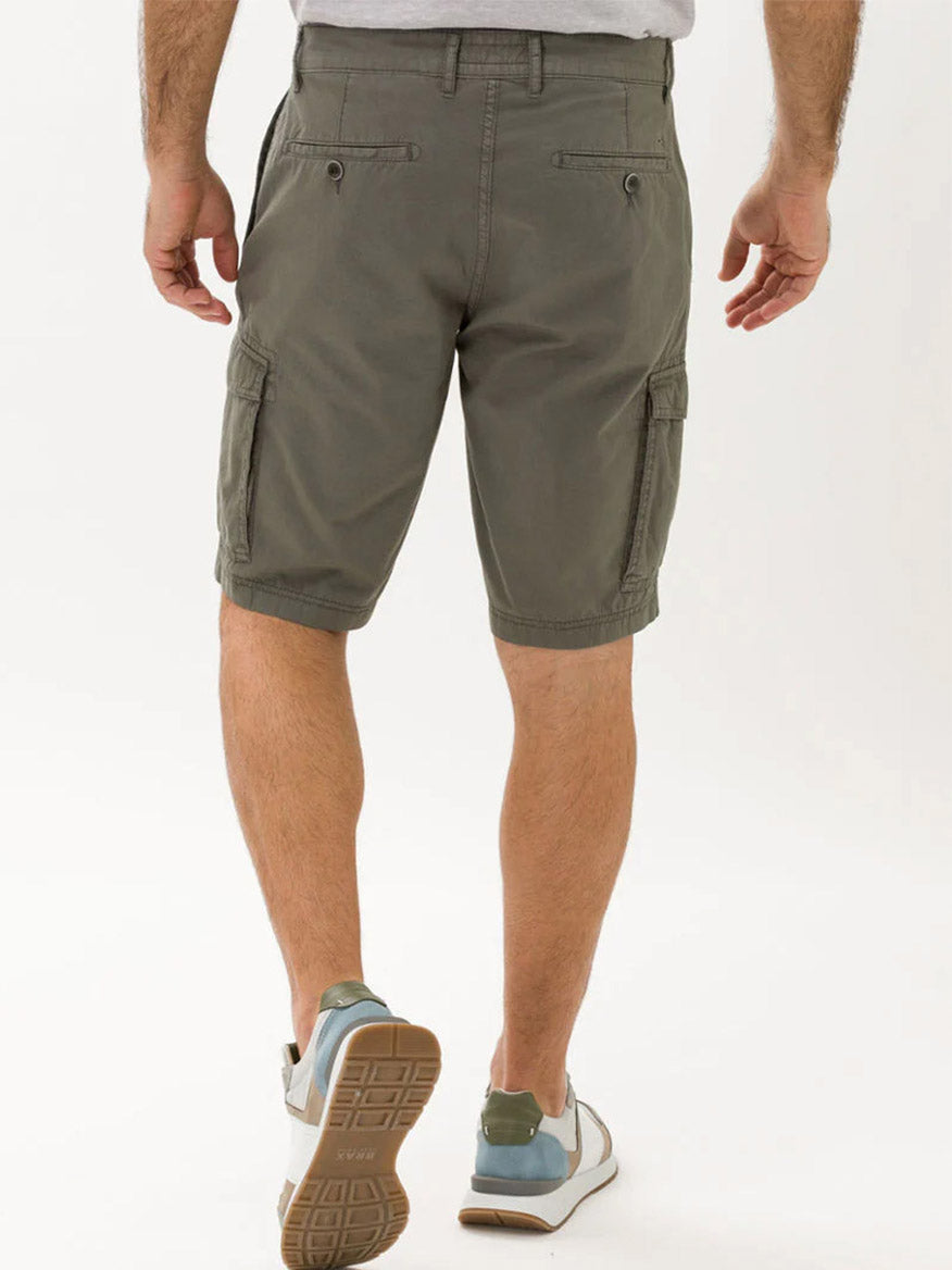 A man wearing Brax Brazil Cargo Shorts in Khaki and sneakers standing with his hands at his sides.