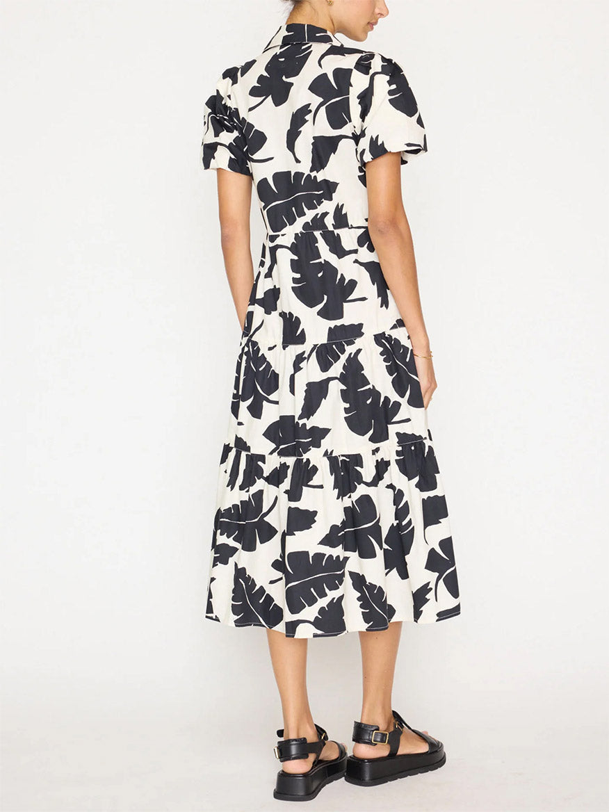 Woman from behind wearing a Brochu Walker Havana Dress in Tropical Combo with a black and white leaf pattern, paired with black platform sandals.