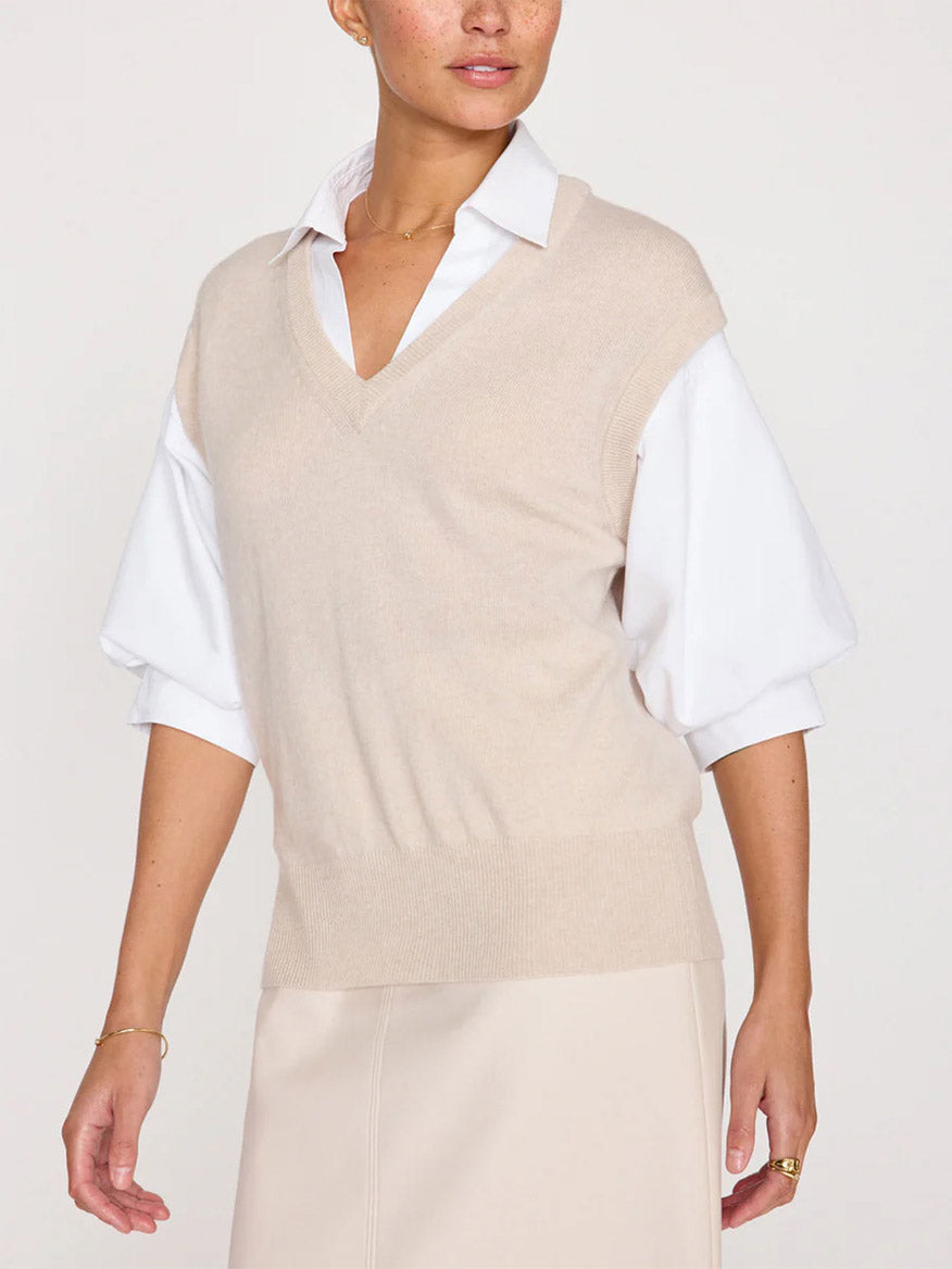 Person wearing a Brochu Walker Kate Shirt Looker in Almond Buff Melange—a beige sleeveless v-neck over a white collared shirt with dramatic blouson sleeves.