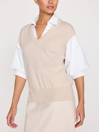 Person wearing a Brochu Walker Kate Shirt Looker in Almond Buff Melange—a beige sleeveless v-neck over a white collared shirt with dramatic blouson sleeves.