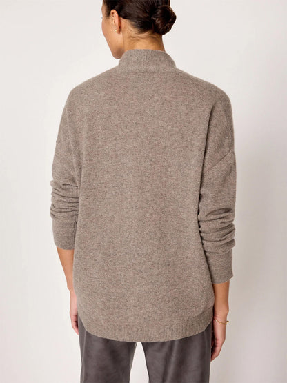 A person with their hair in a bun is seen from behind, wearing the Brochu Walker Siena Wrap Neck Pullover in Otter Melange and gray pants, exuding an air of luxe femininity.