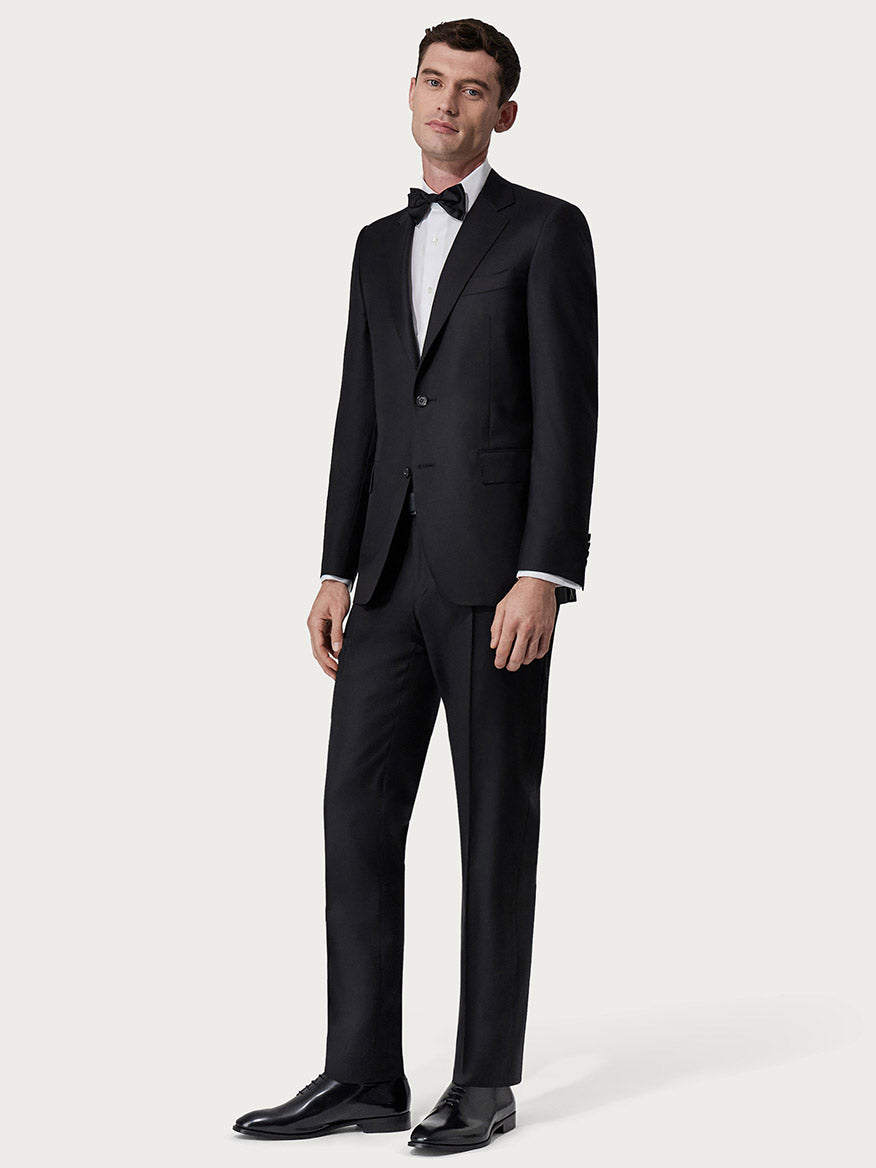 A young man dressed in a Canali Siena Contemporary Black Wool Suit, standing against a plain light background.