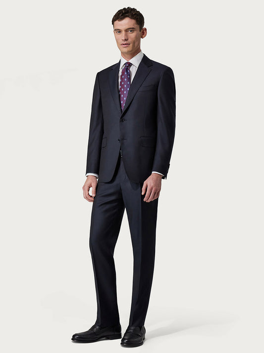 A man in a tailored, single-breasted Canali Siena Contemporary Navy Blue Wool suit with a light purple tie standing against a neutral background.