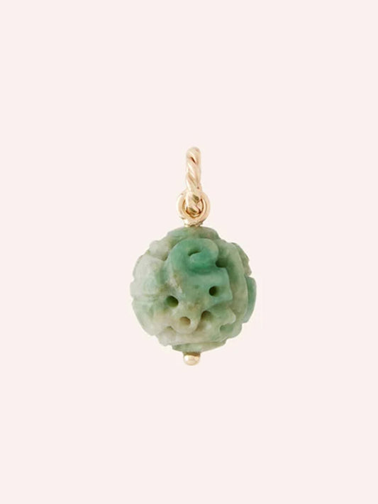 The Clara Williams 14K Green Jade Carved Charm, featuring an intricately carved green-white jade bead attached to a petite 14K yellow gold loop—perfect as a pendant or charm—is displayed against a plain light background.