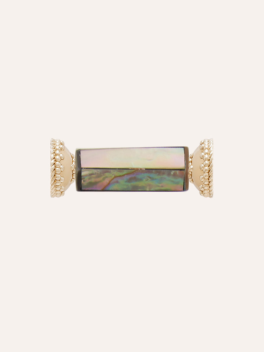 The Clara Williams Abalone Shell Mosaic Hexagon Barrel Mini Centerpiece features a rectangular abalone shell gemstone set horizontally in a gold-toned frame accented with beaded detailing at both ends, creating a striking focal point against a simple background.