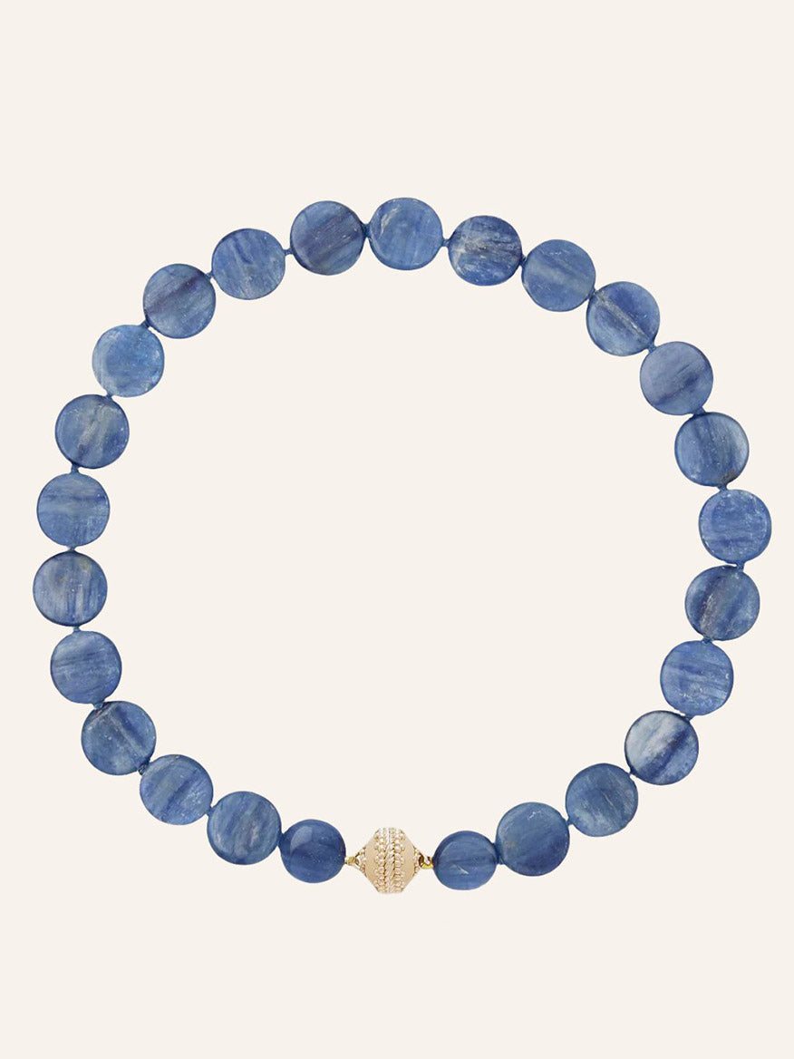 The Clara Williams Blue Kyanite Coin Necklace features round Blue Kyanite coin beads arranged in a circle and is finished with a single decorative 14K yellow gold clasp at the bottom center.