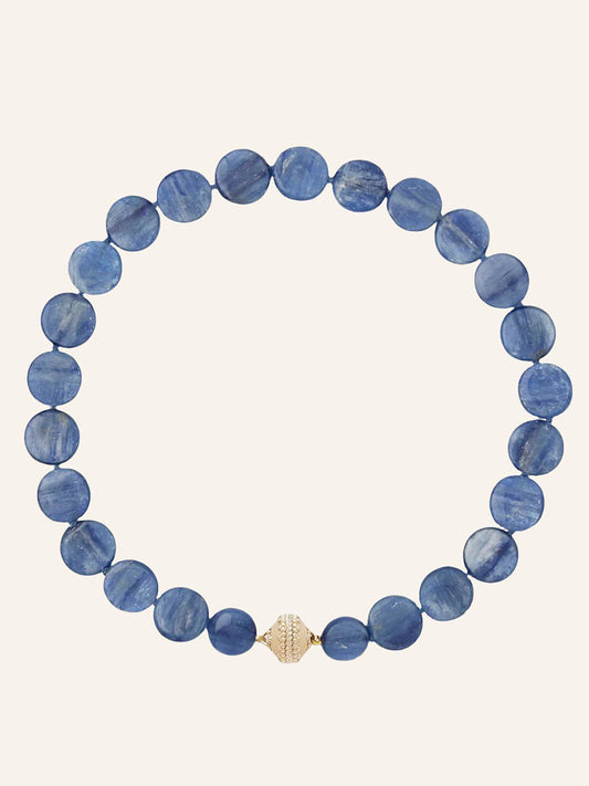 The Clara Williams Blue Kyanite Coin Necklace features round Blue Kyanite coin beads arranged in a circle and is finished with a single decorative 14K yellow gold clasp at the bottom center.