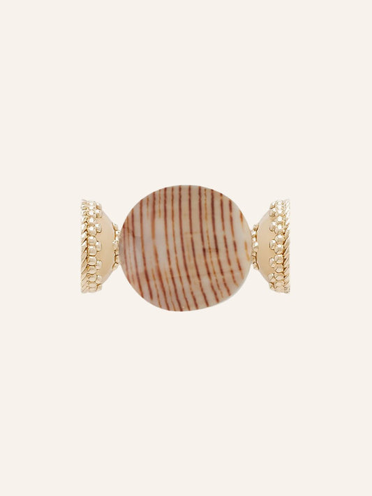 Clara Williams Brown Stripe Shell & Resin Centerpiece ring featuring a round, brown stripe shell accented with textured edges, set in 14K yellow gold and displayed on a plain beige background.