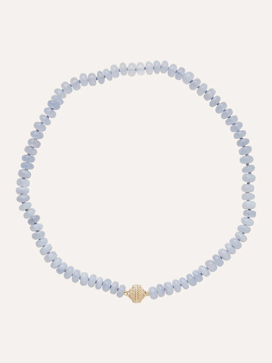 The Clara Williams Chalcedony Rondelle Mini Necklace showcases light blue Blue Chalcedony rondelle stones with a single textured 14K yellow gold bead at the center, displayed on a plain background.