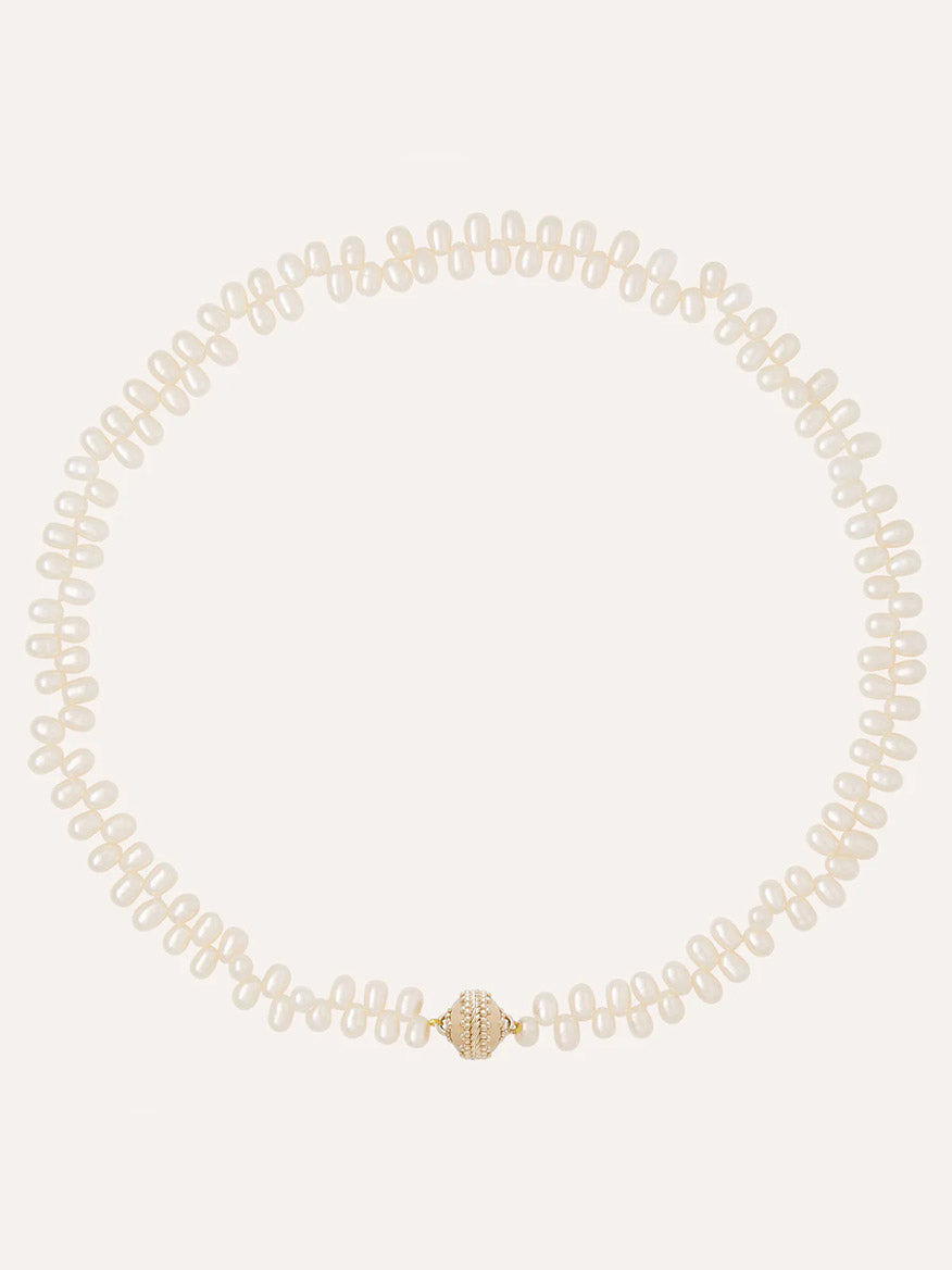 The Clara Williams Freshwater Drop Pearl Mini Necklace features evenly spaced freshwater pearls and a 14K gold clasp with a central grooved design.