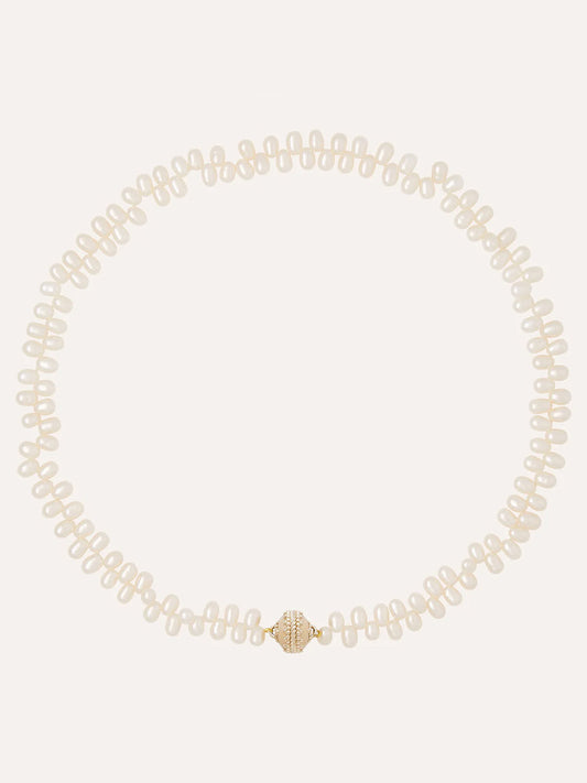The Clara Williams Freshwater Drop Pearl Mini Necklace features evenly spaced freshwater pearls and a 14K gold clasp with a central grooved design.