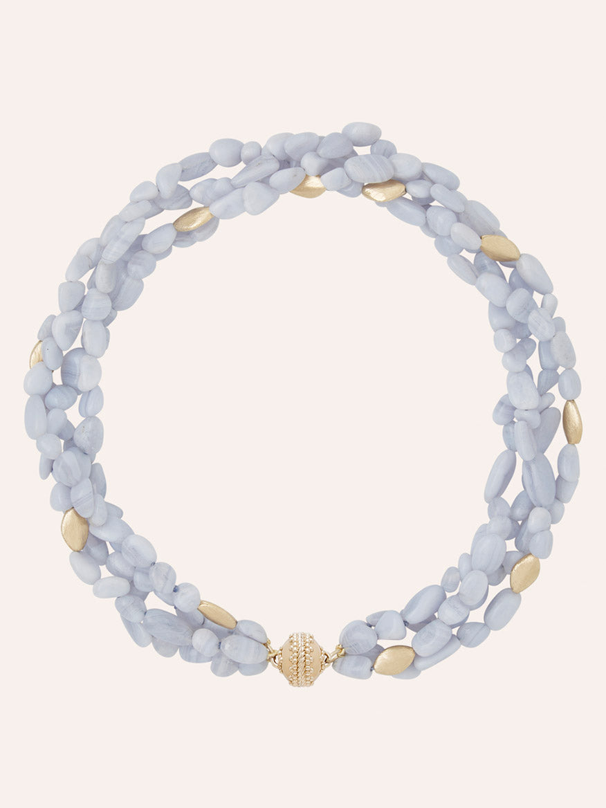 Clara Williams Gold Rush Blue Lace Agate Multi-Strand Necklace, adorned with light blue and gold oval beads and finished with a round 14K Yellow Gold Magnetic ClaraClasp, is displayed on a plain light background.