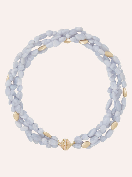 Clara Williams Gold Rush Blue Lace Agate Multi-Strand Necklace, adorned with light blue and gold oval beads and finished with a round 14K Yellow Gold Magnetic ClaraClasp, is displayed on a plain light background.