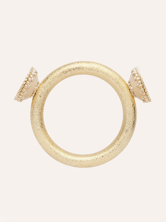Clara Williams Halo Gold Centerpiece bracelet featuring a gold textured circular design with two white, round endcaps—each bordered by a gold beaded trim and highlighted by a subtle halo gold centerpiece—displayed on a plain light background.
