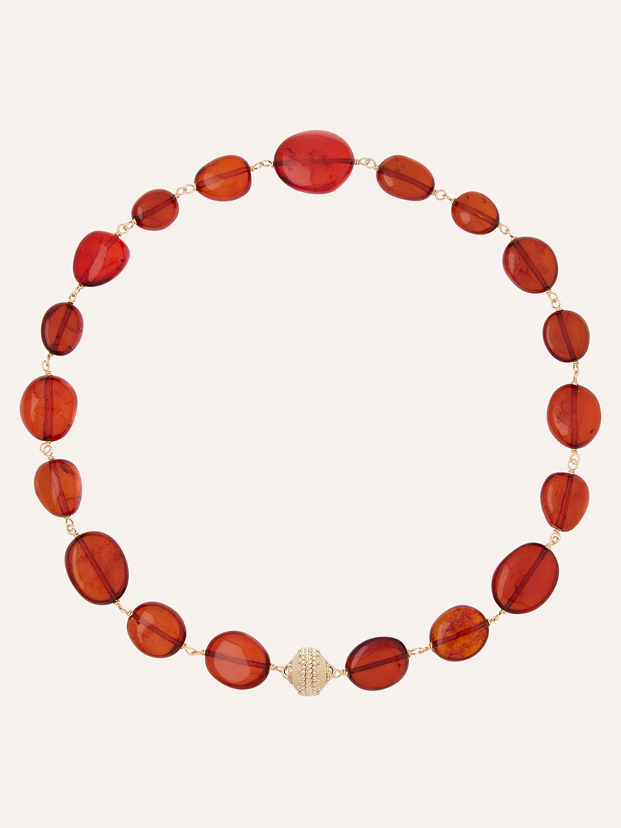 The Clara Williams Helen Caspian Baltic Amber Necklace features translucent oval red-brown Baltic amber beads linked with 14K yellow gold wire and is finished with a gold textured Magnetic ClaraClasp at the bottom center.