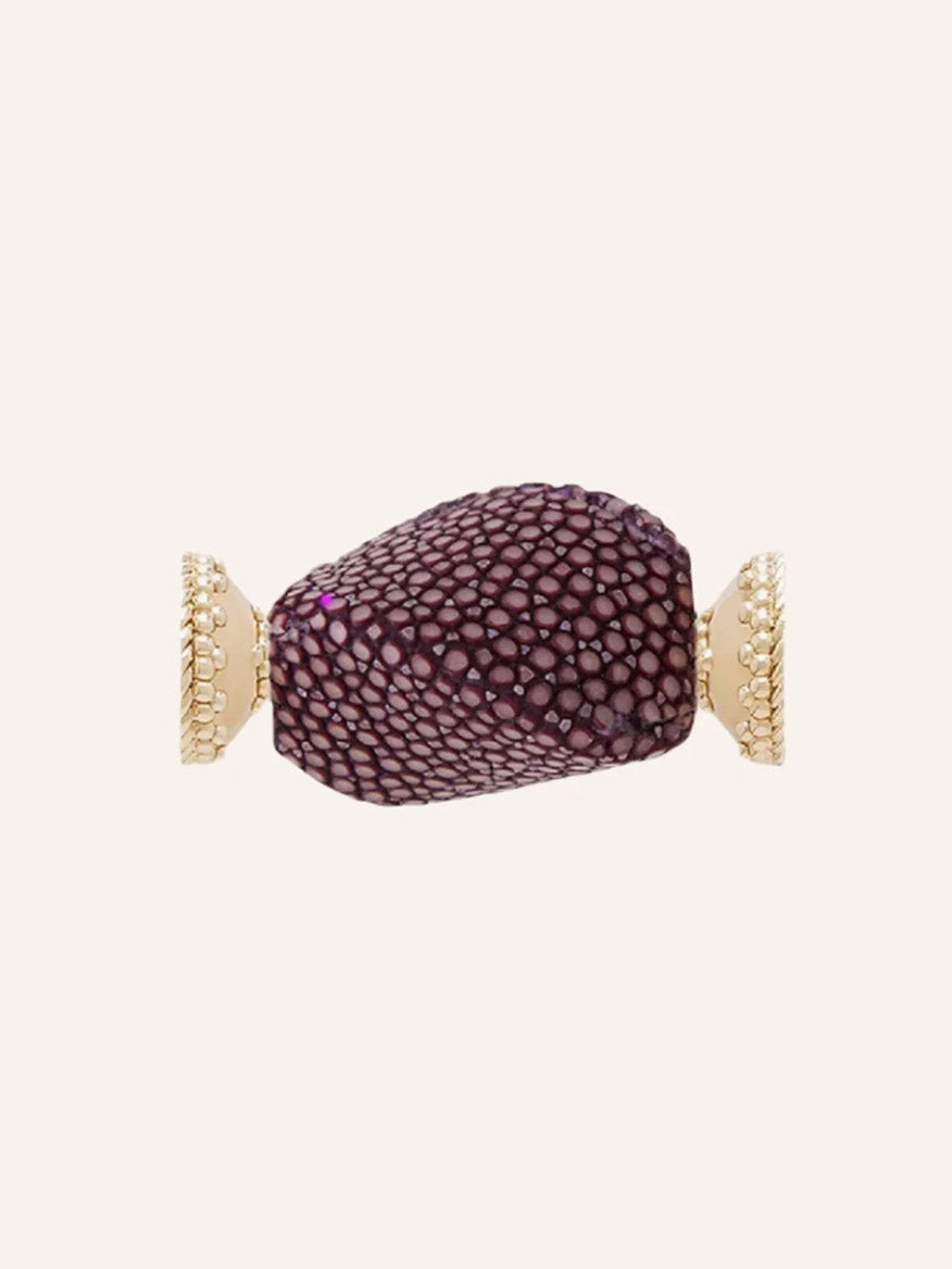 Clara Williams Small Plum Stingray Centerpiece gold cuff bracelet featuring a central, textured plum stingray stone with a rich purple finish and 14K yellow gold details on each end, set against a plain background.