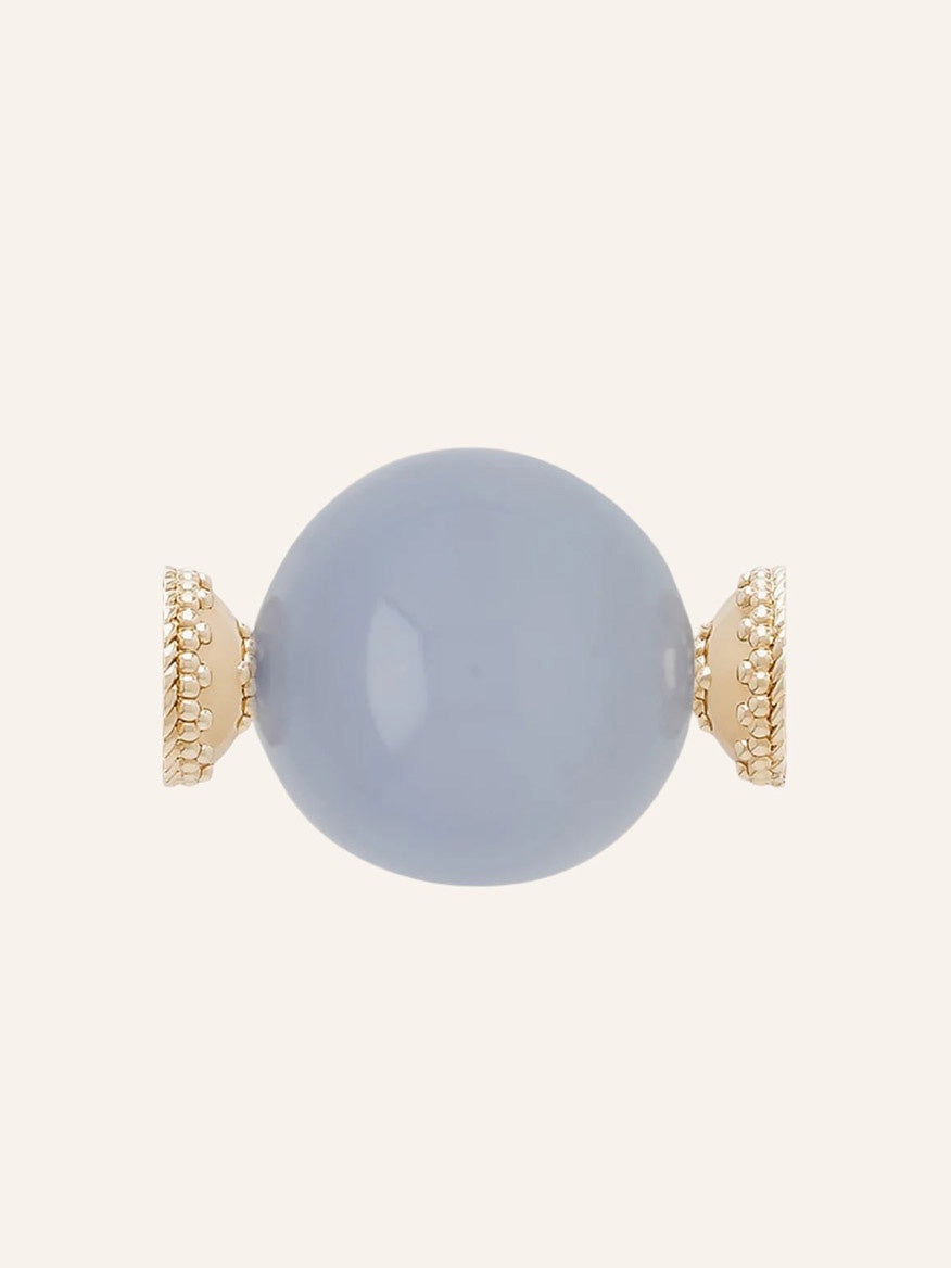 The Clara Williams Victoire 27mm Chalcedony Centerpiece features a round, pale blue chalcedony gemstone set horizontally between two textured 14K yellow gold end caps, displayed against a neutral background.